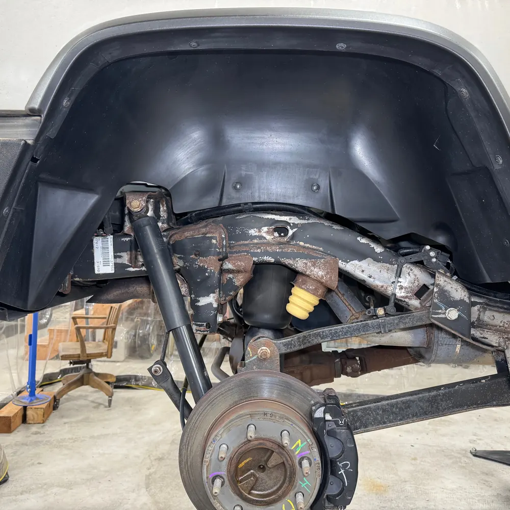 The same rear wheel well after dry ice cleaning, grime and loose scale removed down to the metal